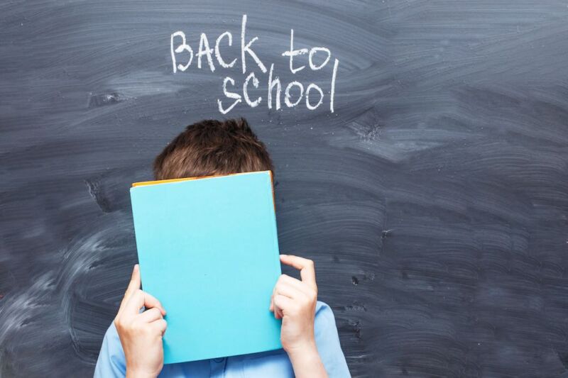 child-boy-covered-his-face-with-a-textbook-