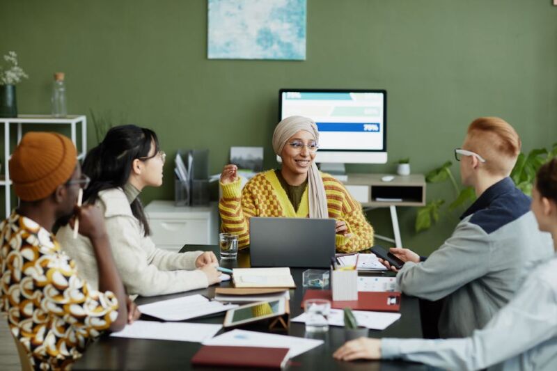 smiling-female-manager-talking-to-young-team-